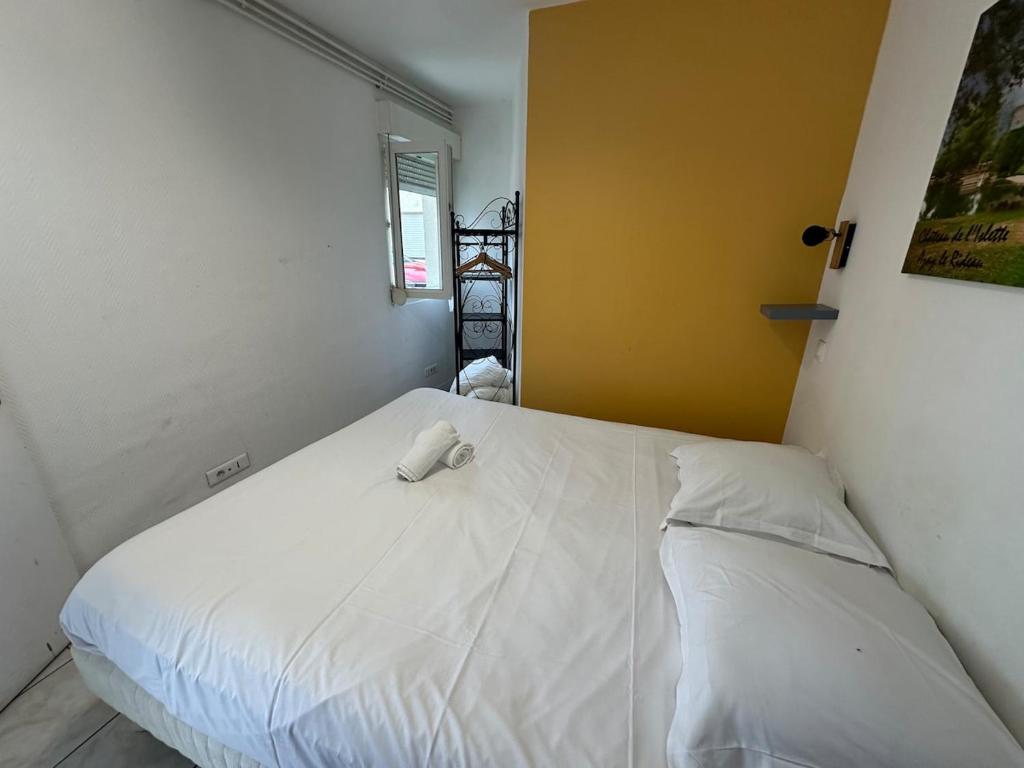 a white bed in a room with a window at Appartement 2 chambres au coeur de St Cyr avec parking privé in Saint-Cyr-sur-Loire
