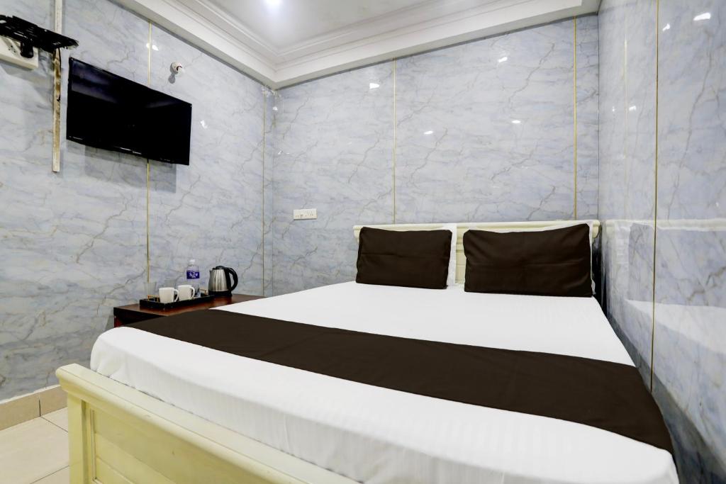 a bedroom with a bed with a tv on the wall at Spot On Sri Balaji in Vijayawāda
