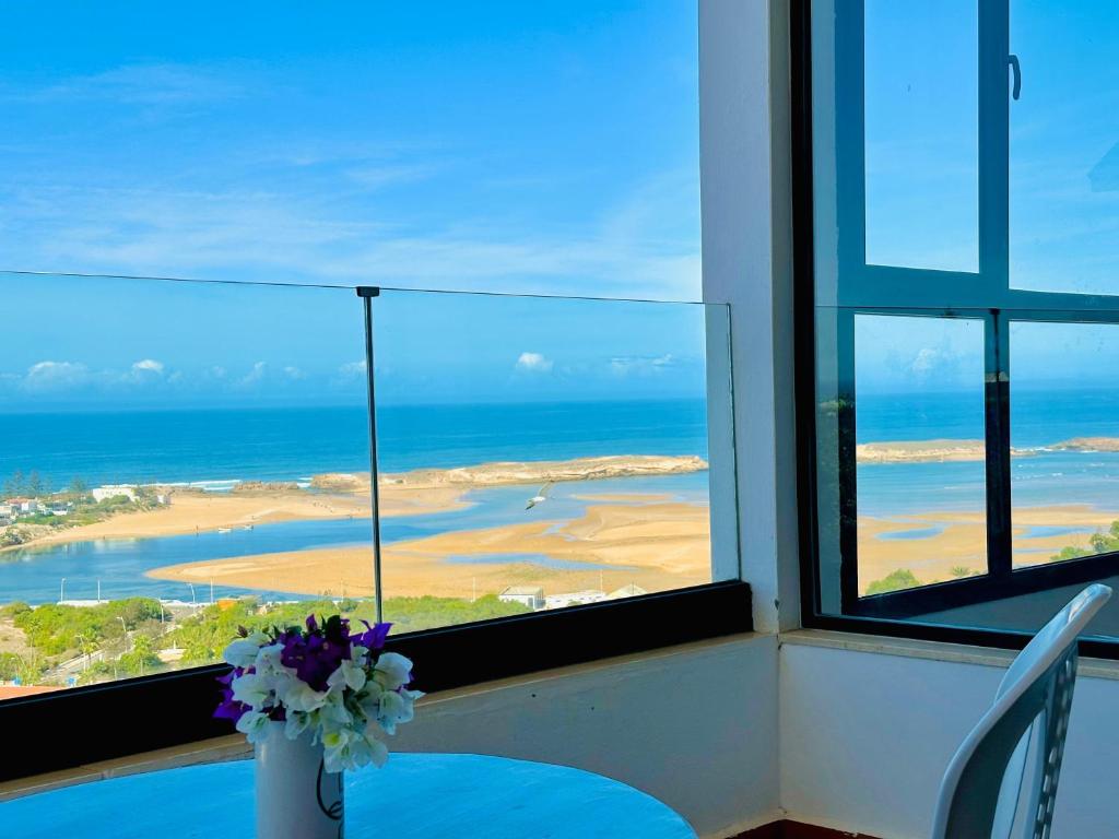 a room with a table and a view of the ocean at Appartement Coucher de Soleil Vue sur Mer pour les familles in Oualidia