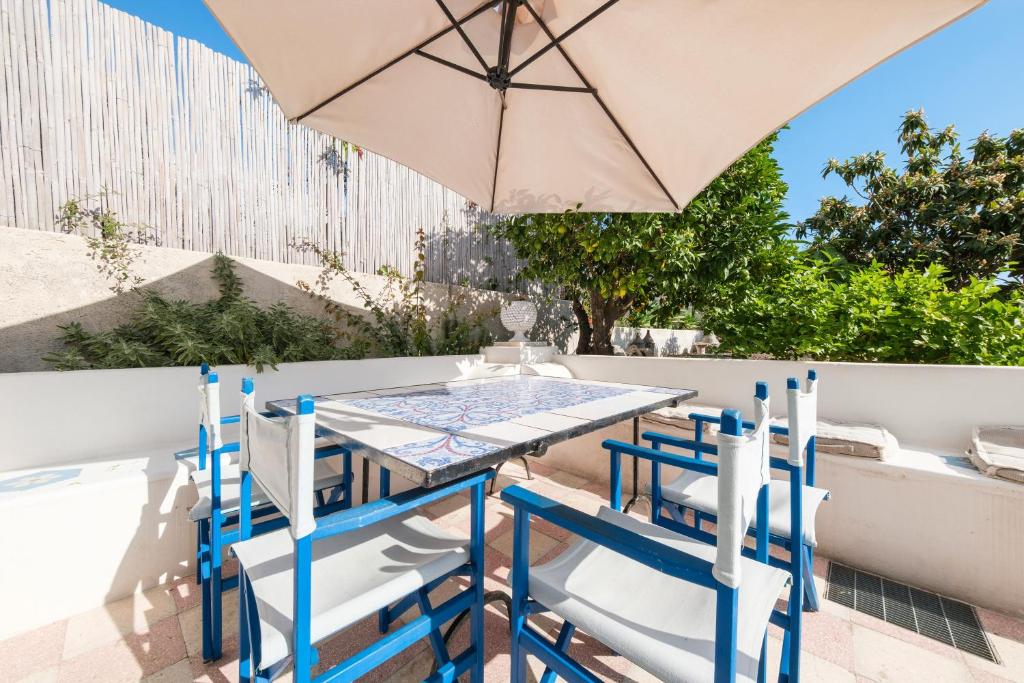 a table and chairs with an umbrella on a patio at La Casa Bianca in Marina
