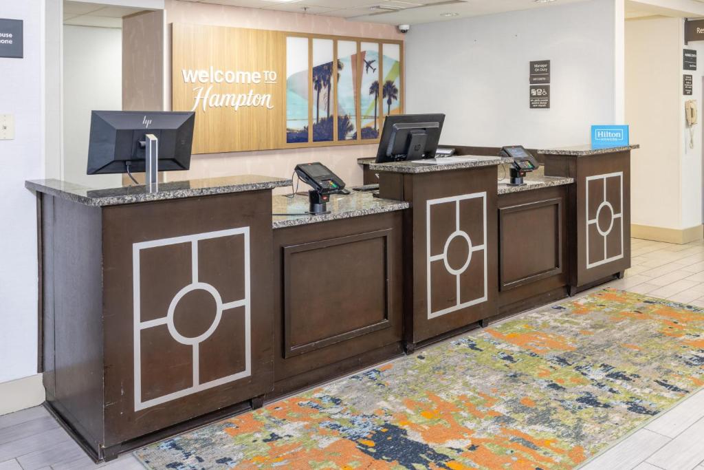 a lobby with three reception desks with cell phones at Hampton Inn Tampa International Airport/Westshore in Tampa