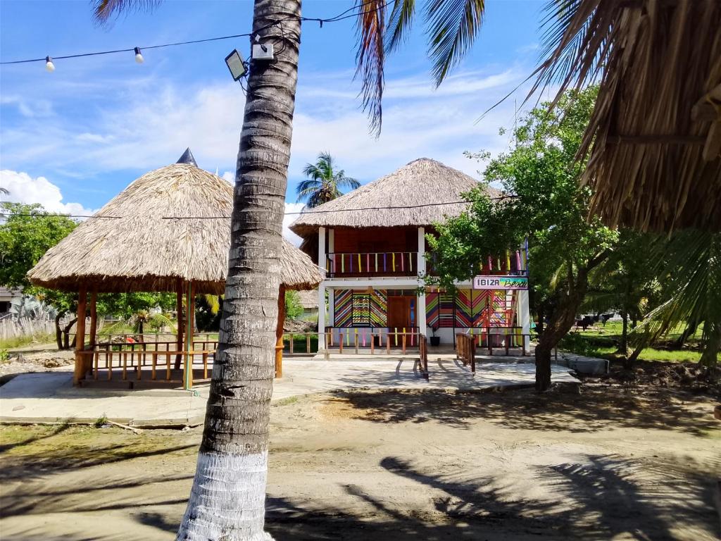 a resort with a palm tree and a building at Ibiza beach in Moñitos