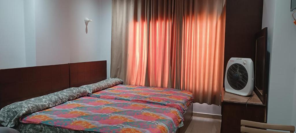 a bedroom with a bed and a clock next to a window at Mirage Bay hotel in Hurghada