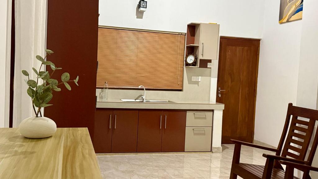 a kitchen with a sink and a table and a window at Opal Heights in Gampaha