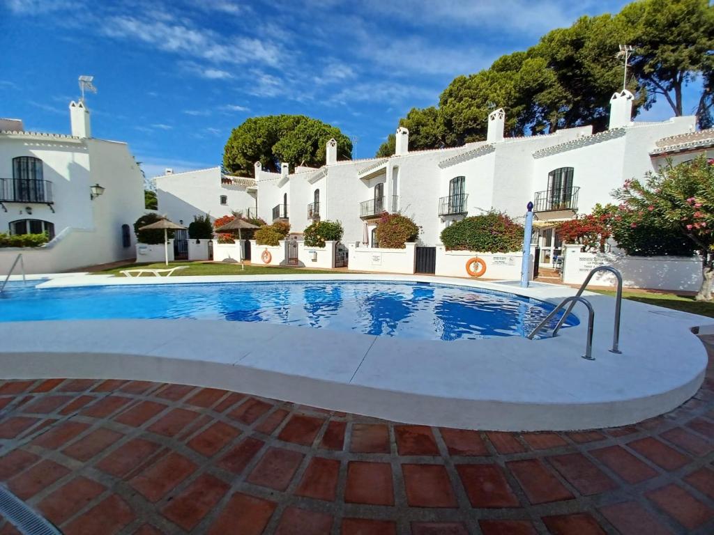 een zwembad voor een wit gebouw bij PINOS 20 MENYBER in Nerja