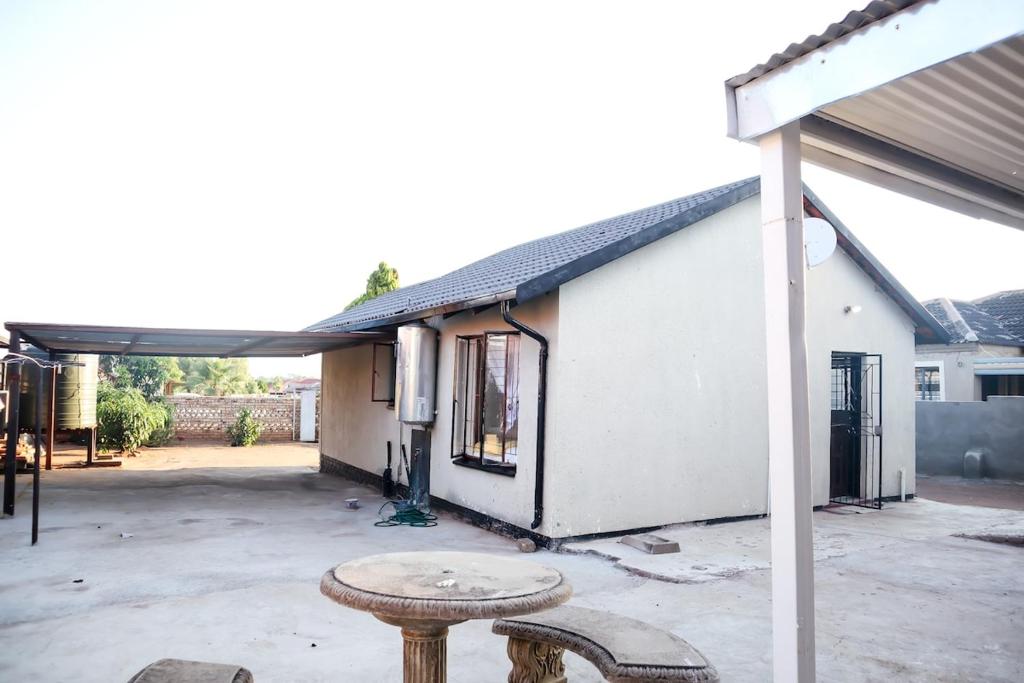 a white building with a table in front of it at Lapeng Mogwase Free Parking-Free WIFI in Mogwase