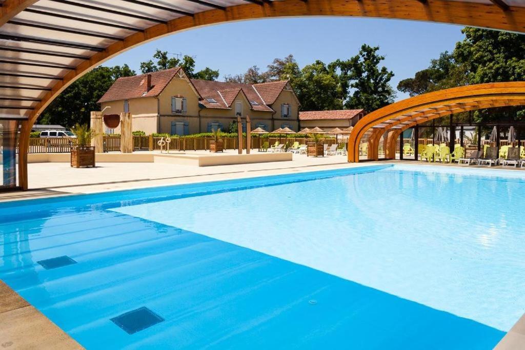 une grande piscine entourée d'une arche dans l'établissement Camping Le Soleil des Landes, à Lit-et-Mixe