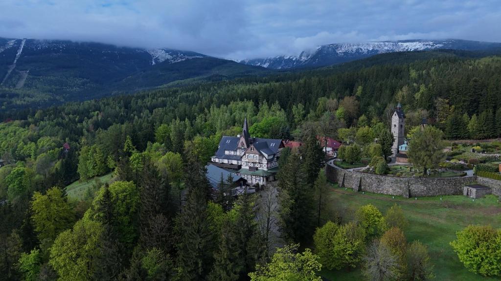 Bird's-eye view of a mountain estate and stone wall surrounded by lush green forest.