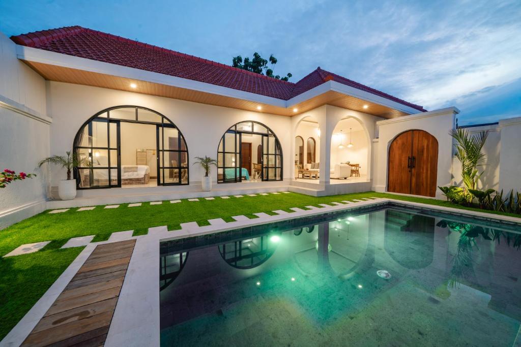 a house with a swimming pool in front of it at Paica House Nusadua in Nusa Dua