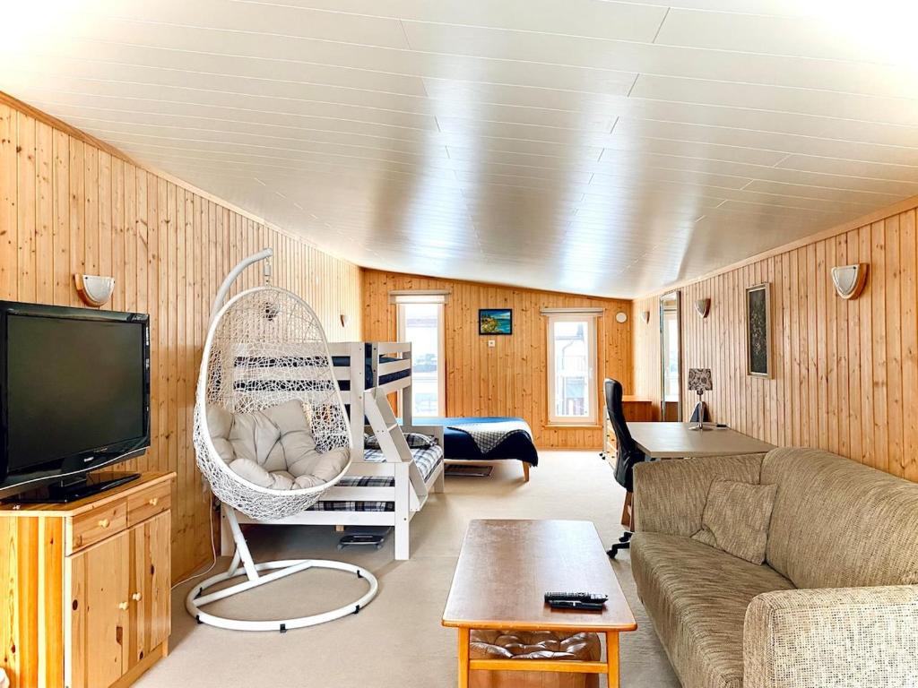 een woonkamer met een bank en een tv bij Cozy Garden House with a Sauna in Tallinn