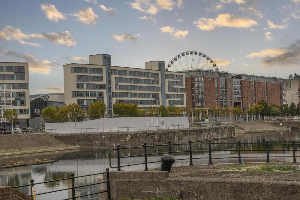 a city skyline with a ferris wheel in the background at Dockside Aparthotel, Best Western Signature Collection in Liverpool