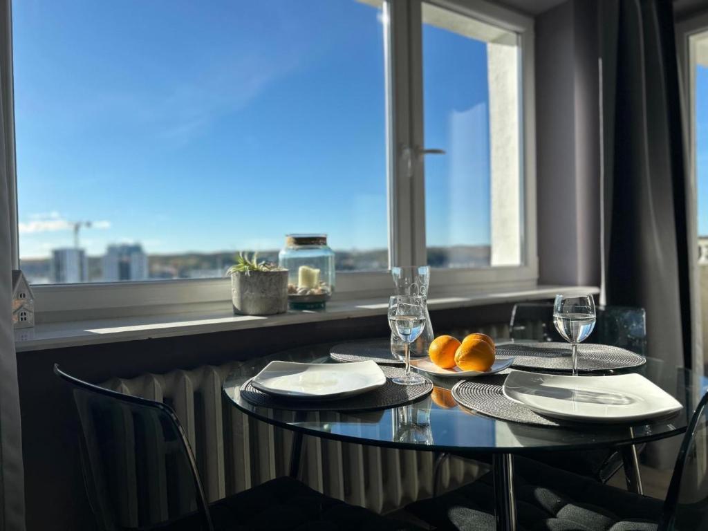 un tavolo con due bicchieri e arance su una finestra di Apartament w RedLovie a Gdynia