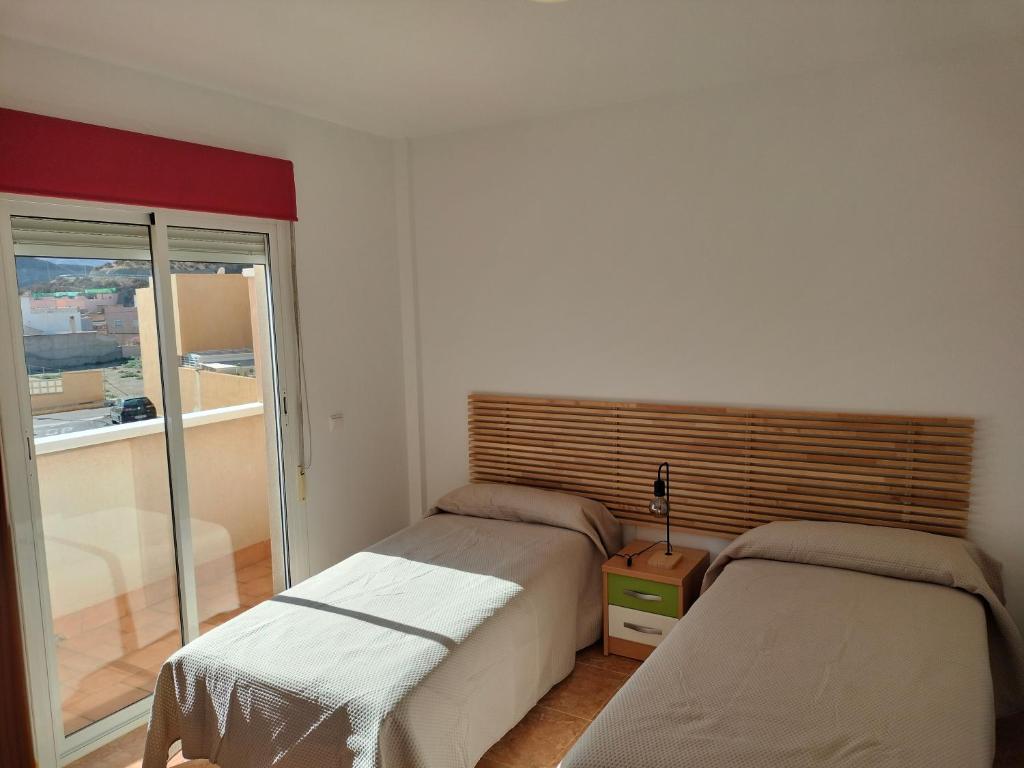 a bedroom with two beds and a balcony at La estrella del desierto in Tabernas