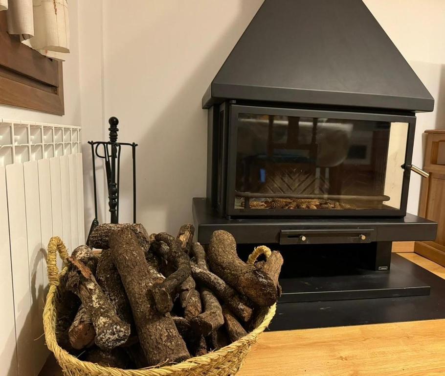 een mand met houtblokken voor een open haard bij Apartamento La brisa Fiscal in Fiscal