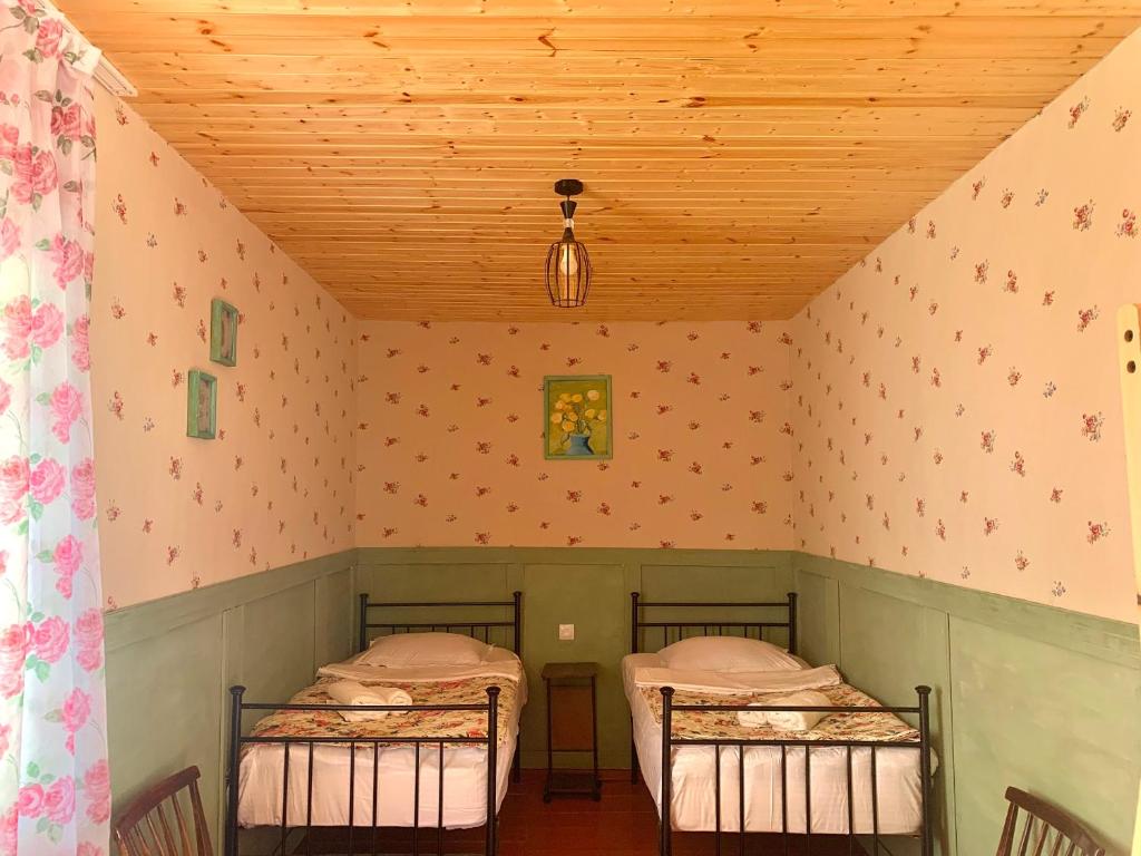 two twin beds in a room with pink walls at Guesthouse Lantia in Mestia