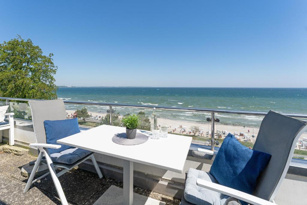 a table and chairs on a balcony with the beach at Hang 13 Wohnung 26 in Scharbeutz