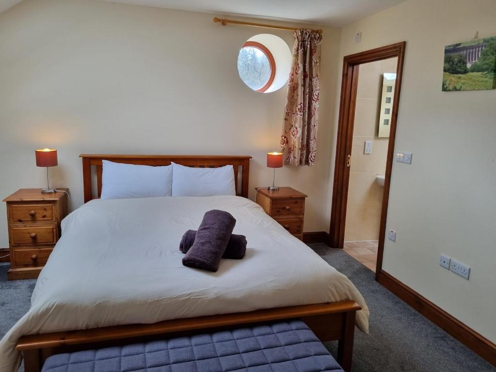 a bedroom with a large bed with two pillows on it at Hobby Stable Cottage in Cynghordy