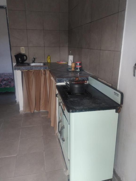 une cuisine avec une cuisinière et un comptoir dans l'établissement Areco en lo de Mabel, à San Antonio de Areco