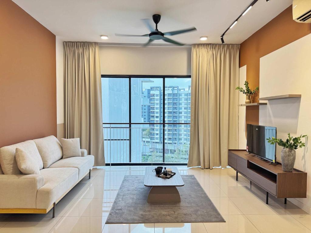 a living room with a couch and a tv at The Jelutong Trio, Spacious 3-Bedroom Luxury Stay in Shah Alam