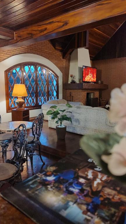 a living room with a table and a couch at Refugio maná in Campos do Jordão
