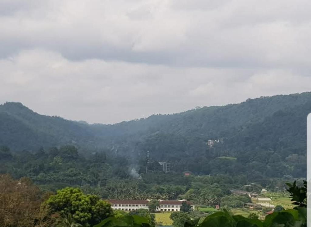 a view of a mountain range with trees and buildings at Sky View Kandy in Kandy
