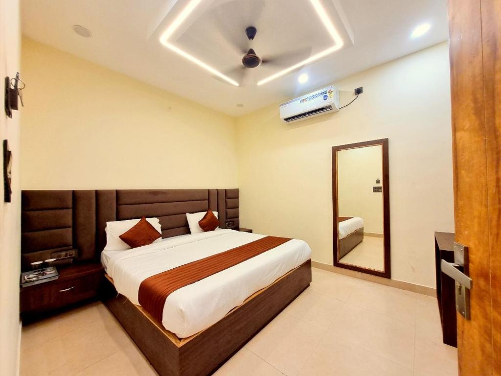 a bedroom with a large bed and a mirror at Atlas Inn Stay Near IGI Airport T3 in New Delhi