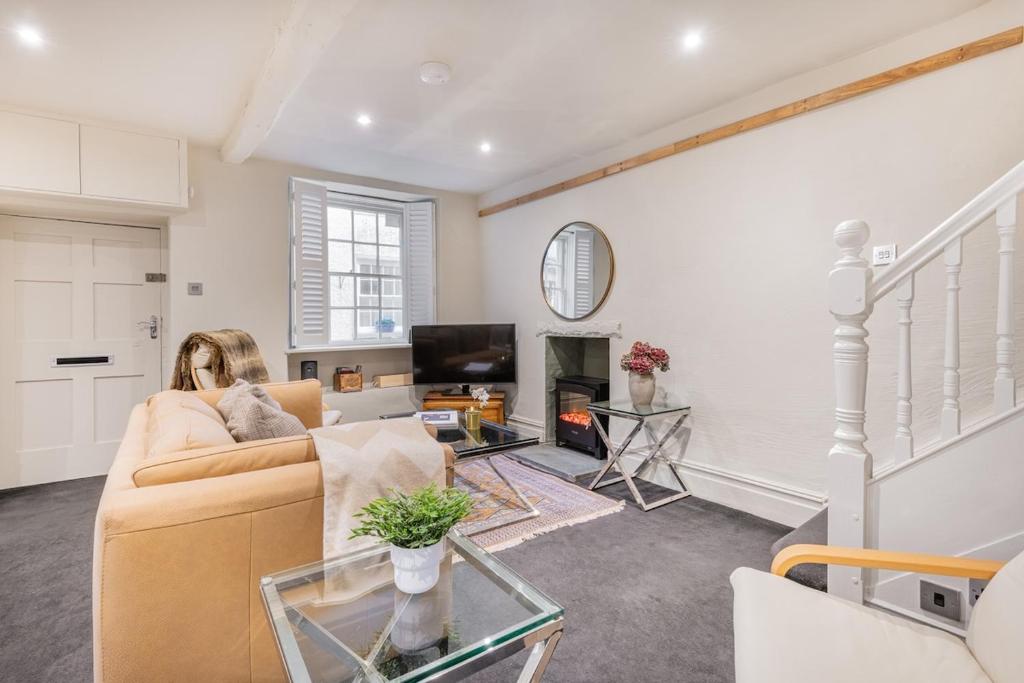 a living room with a couch and a fireplace at Gatehouse Cottage in Cartmel in Rossendale