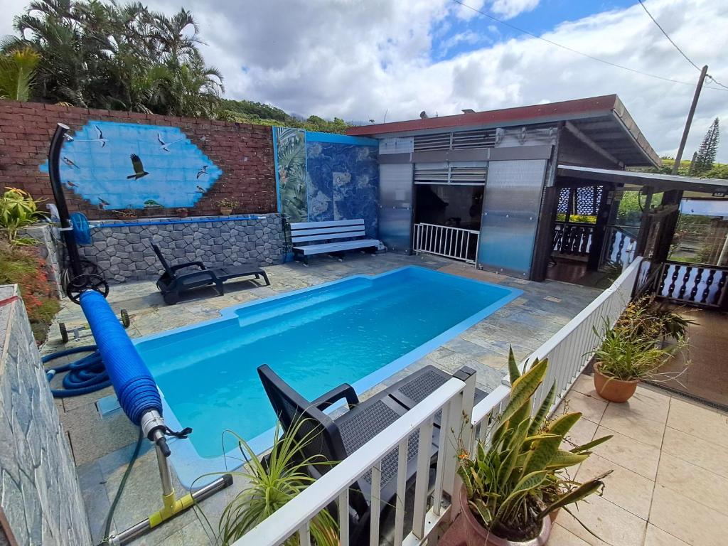 een zwembad in een tuin met een huis bij Maison aux Portes du Sud Sauvage in Saint-Joseph