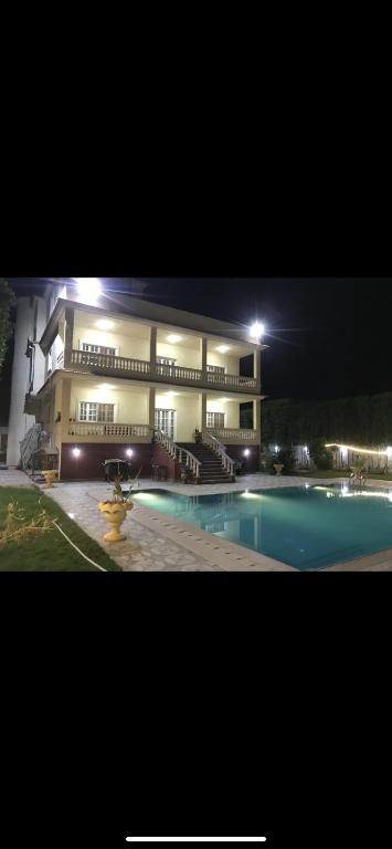 a large building with a swimming pool at night at Allam's Villa - Families only in Borg el Arab
