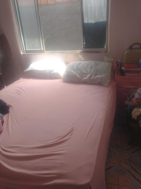 een klein bed in een kamer met een raam bij Quartos para alugar na cop 30 in Ananindeua