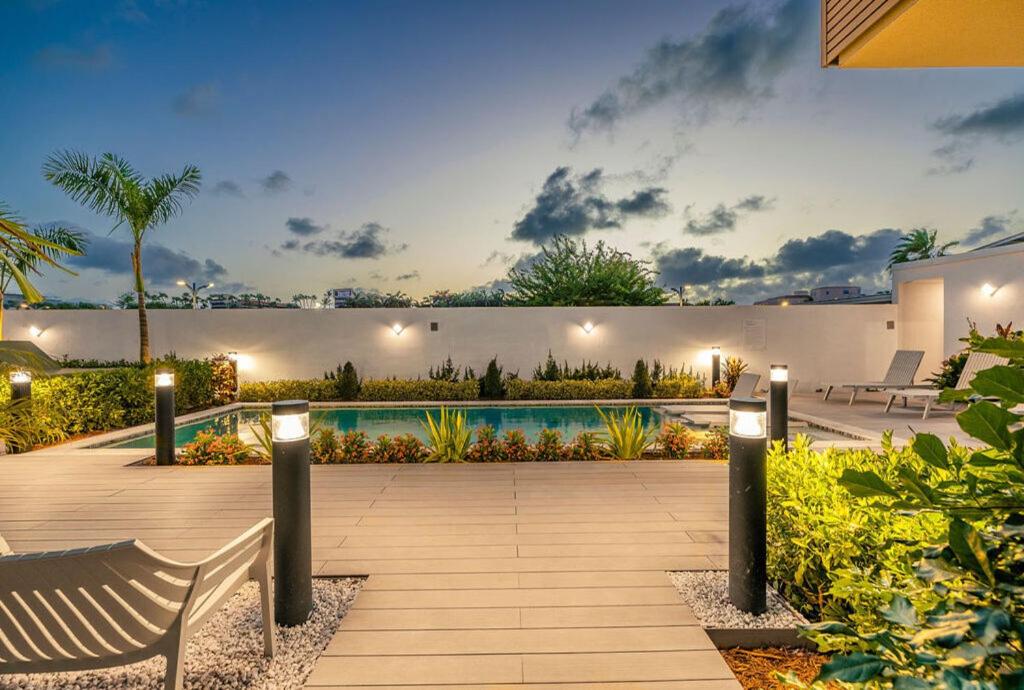 een achtertuin met een zwembad en een bank bij Luxury 2BR Condo w/Pool, Rooftop, GYM @ Palm Beach in Palm-Eagle Beach