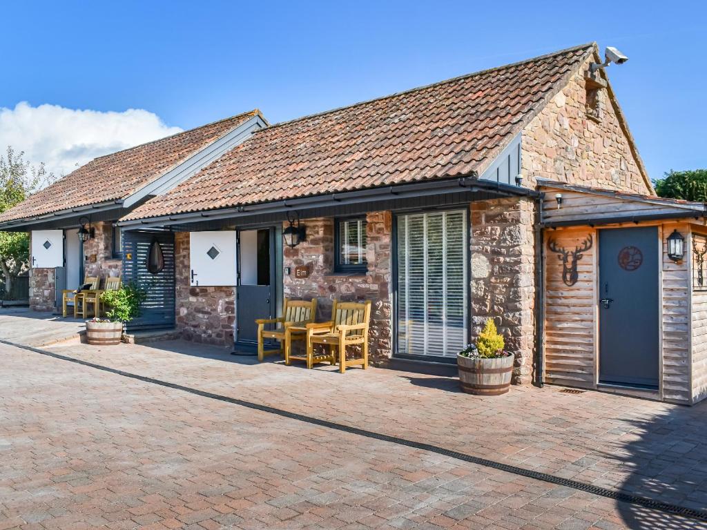 a stone cottage with a patio in front of it at Elm - Uk50463 in Alvington