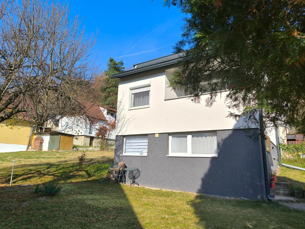 una casa blanca y gris con patio en Döbrönte MagLak, en Döbrönte