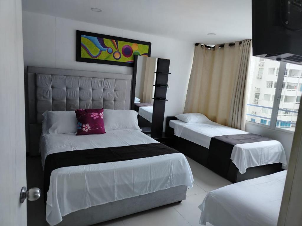een hotelkamer met twee bedden en een raam bij Atardeceres del Laguito in Cartagena