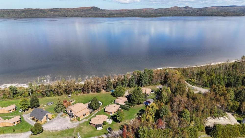 an aerial view of a house next to a lake at Charmant Petit Condo Ski in Val-Brillant