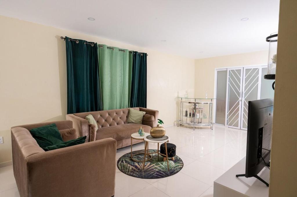 Una sala de estar con un sofá y un televisor. en The Blue Nest, en Dorp Sint Michiel