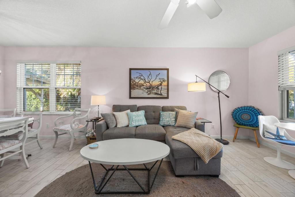 een woonkamer met een bank en een tafel bij Relaxing beach getaway just steps to the shore in Coquina Gables