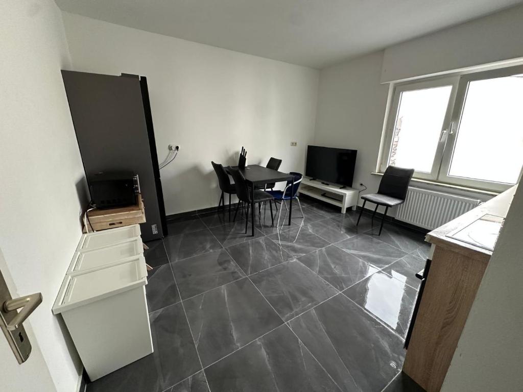 a living room with a table and chairs and a television at HAI1 - Morderne Unterkunft mit Einzelzimmer in Hainburg