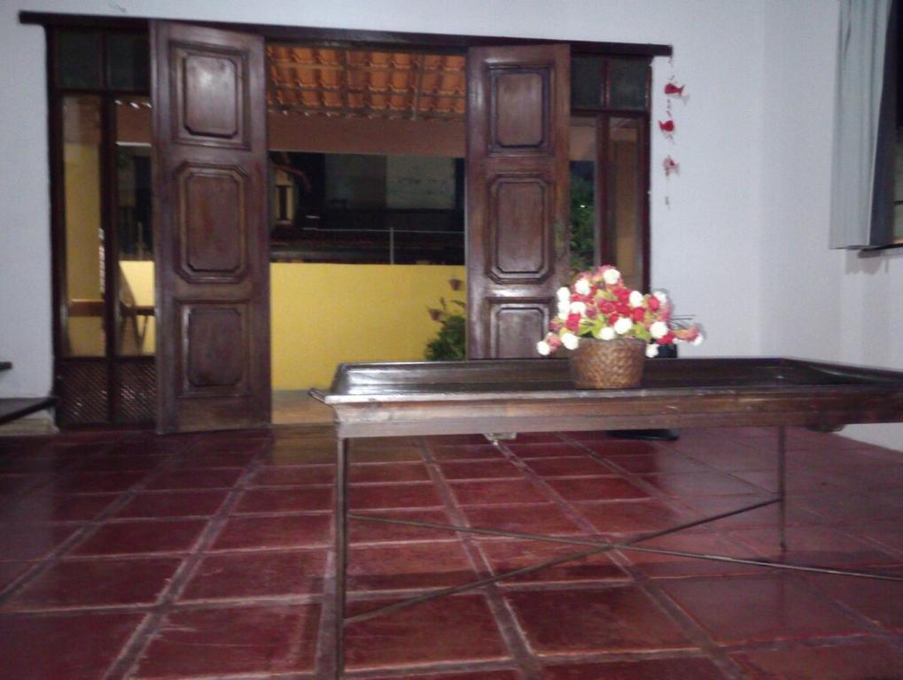 un banc en bois avec un arrangement floral dessus dans l'établissement Casa independente com piscina emCabo Frio RJ, à Cabo Frio