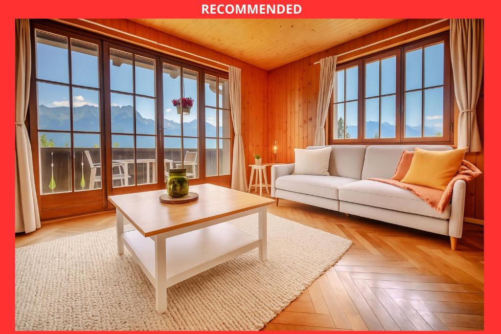 a living room with a white couch and a table at Chalet 6 personnes avec sauna in Leysin