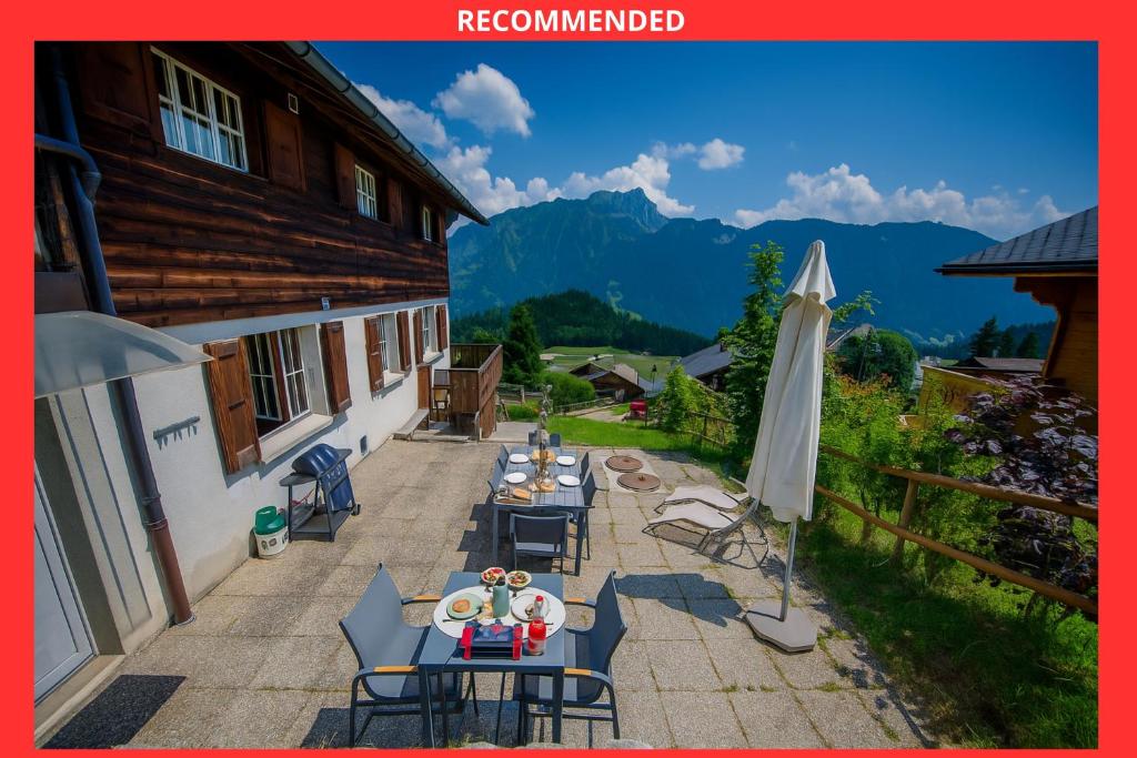 an overhead view of a patio with tables and an umbrella at Studio loft avec sauna in Leysin