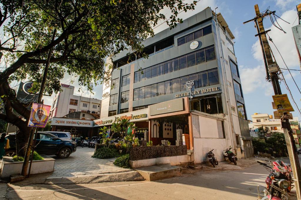 a building on a city street with cars parked in front at Silverkey Hotel Yelahanka in Bangalore