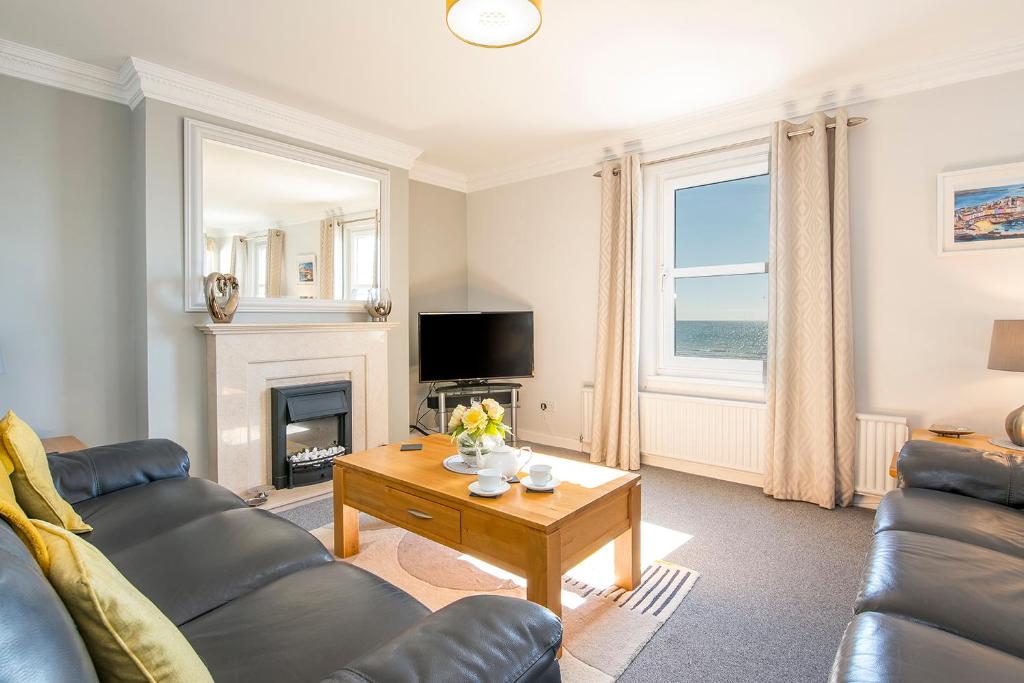 a living room with a couch and a table at Pebble Reach in Amroth