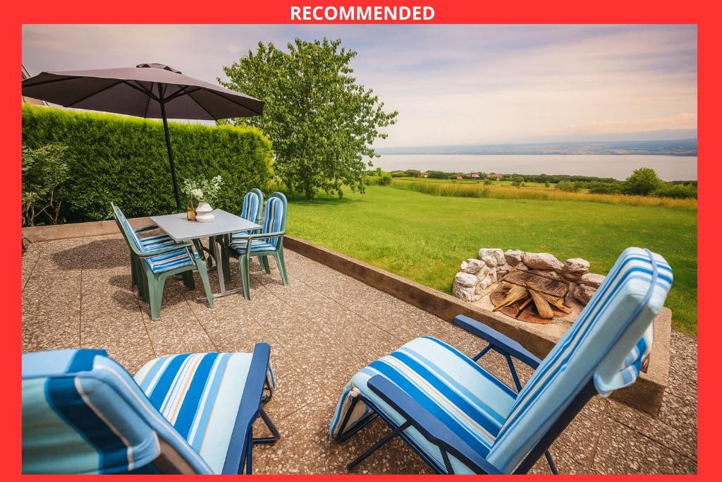 a patio with chairs and a table with an umbrella at Chalet vue Alpes et lac in Provence