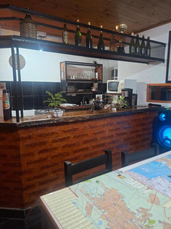 a bar in a restaurant with a table and a counter at Posada Ruta 65 in General Fernández Oro