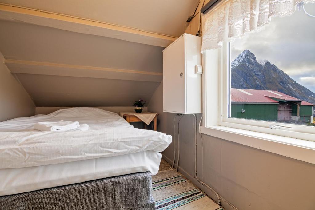a small bedroom with a bed and a window at Heimly, cosy house in a fjord in Bjørnsand