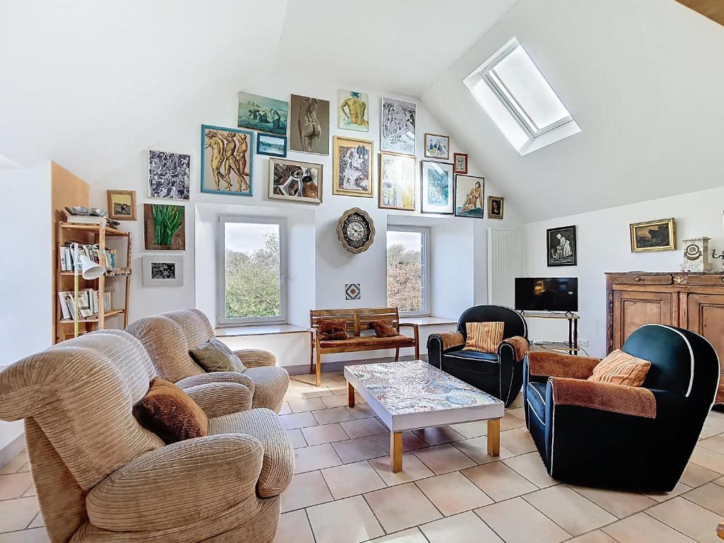a living room with couches and chairs and a table at La Mainerie in Jobourg