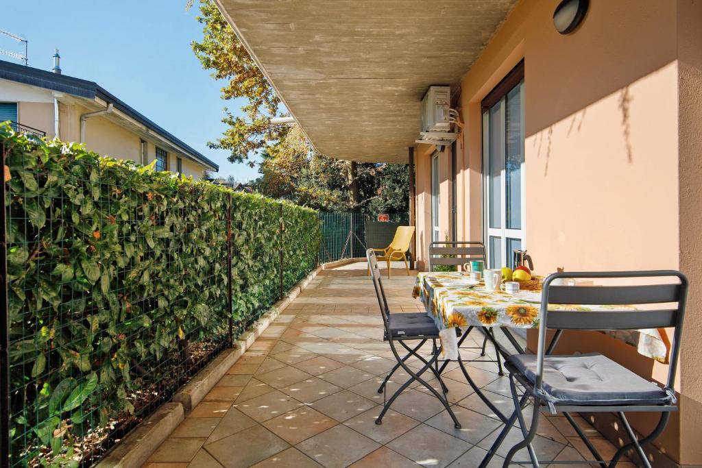 a table and chairs on a patio next to a hedge at Casa Martina in San Fermo della Battaglia