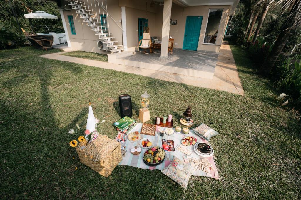 ein Picknicktisch im Gras mit Essen drauf in der Unterkunft amã Stays & Trails - Assa 360 , Goa in Assagao