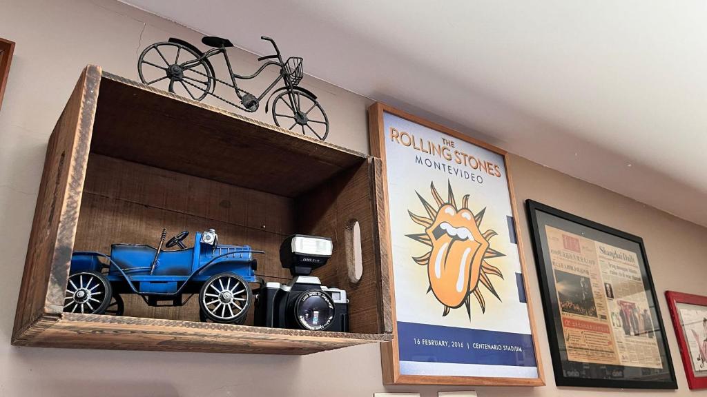 a wooden shelf with a toy car and a sign at La Nueva Posadita in Colonia del Sacramento